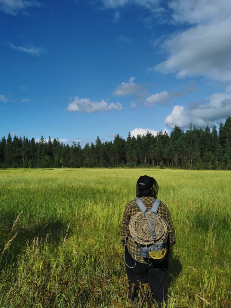 Michael wearing his new outdoor workshirt in an open field surrounded by the woods.
