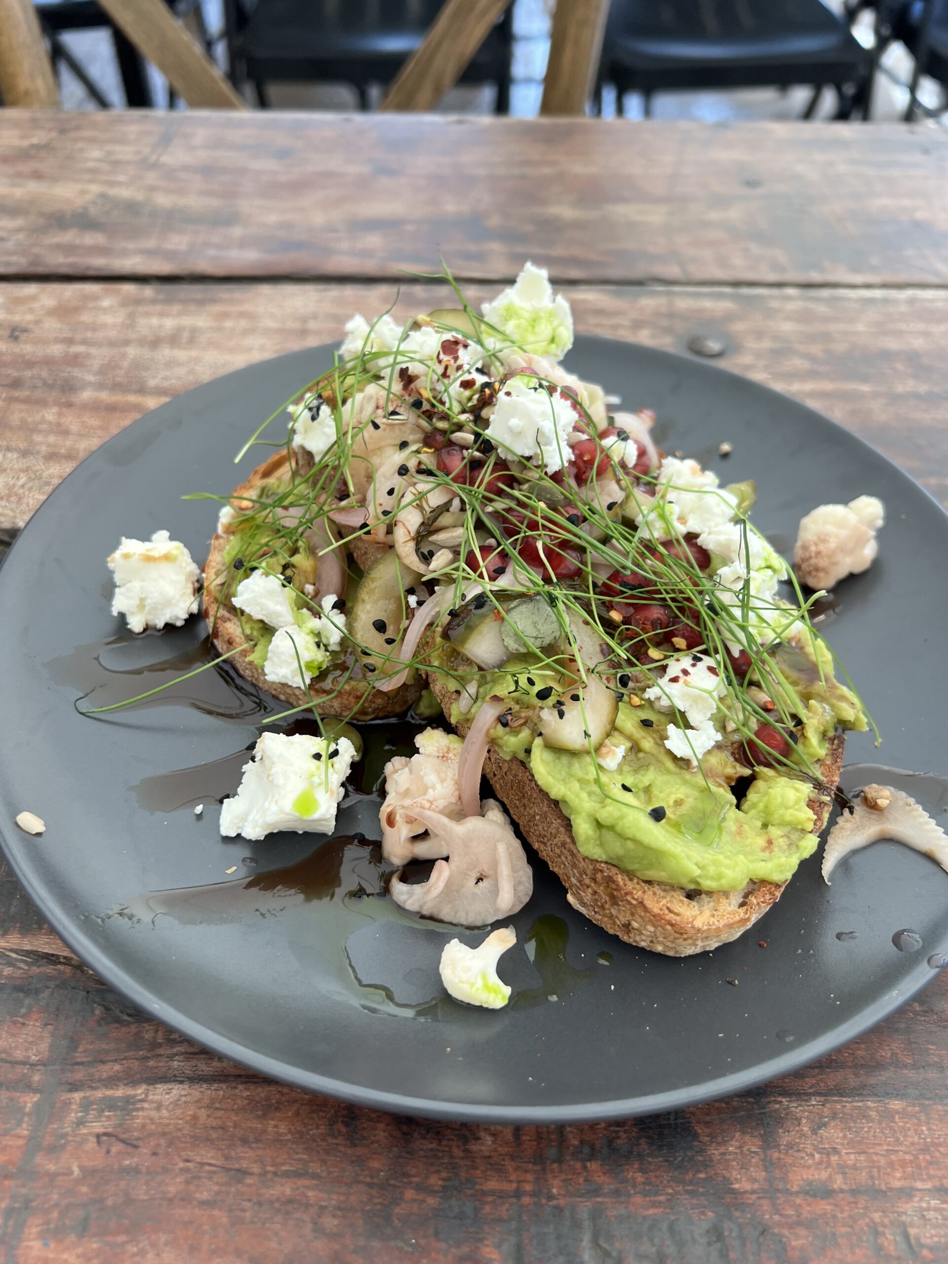 Avocado toast from the Yard cafe. It is topped with pickled veg, feta, and chives.